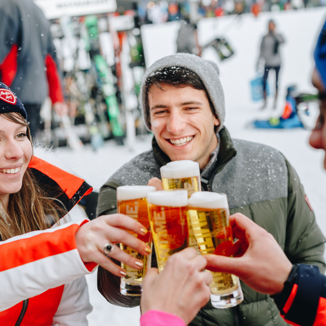 Et levende fyrværkeri oplyser et sneklædt bjerglandskab om natten under Nytår på ski, med striber af lys på himlen, der tilføjer dynamisk bevægelse til scenen.