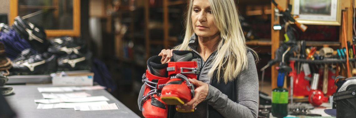 Skiduthyrning - anställd i skidbutik som delar ut pjäxor