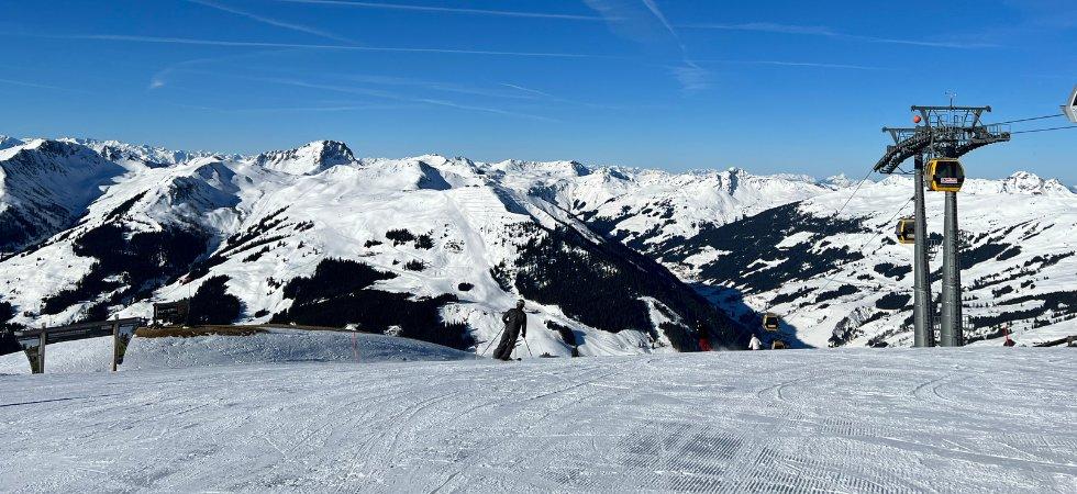 Snötäckta berg under en klarblå himmel med lifttorn och kablar till höger och skidspår i förgrunden - perfekt för en skiferie i Saalbach.