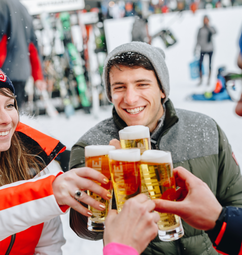 Et levende fyrværkeri oplyser et sneklædt bjerglandskab om natten under Nytår på ski, med striber af lys på himlen, der